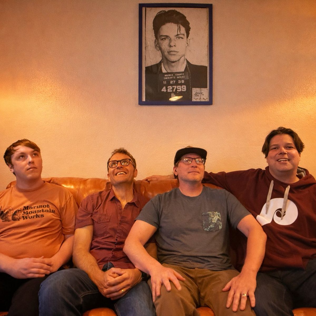The Andes sitting on a leather couch beneath a framed Frank Sinatra mugshot