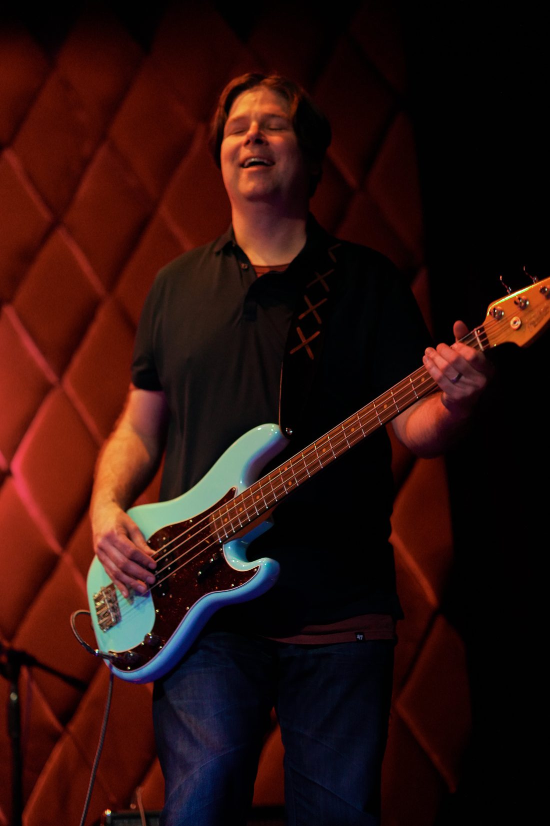 Bassist playing a sea-foam Fender Precision bass on stage