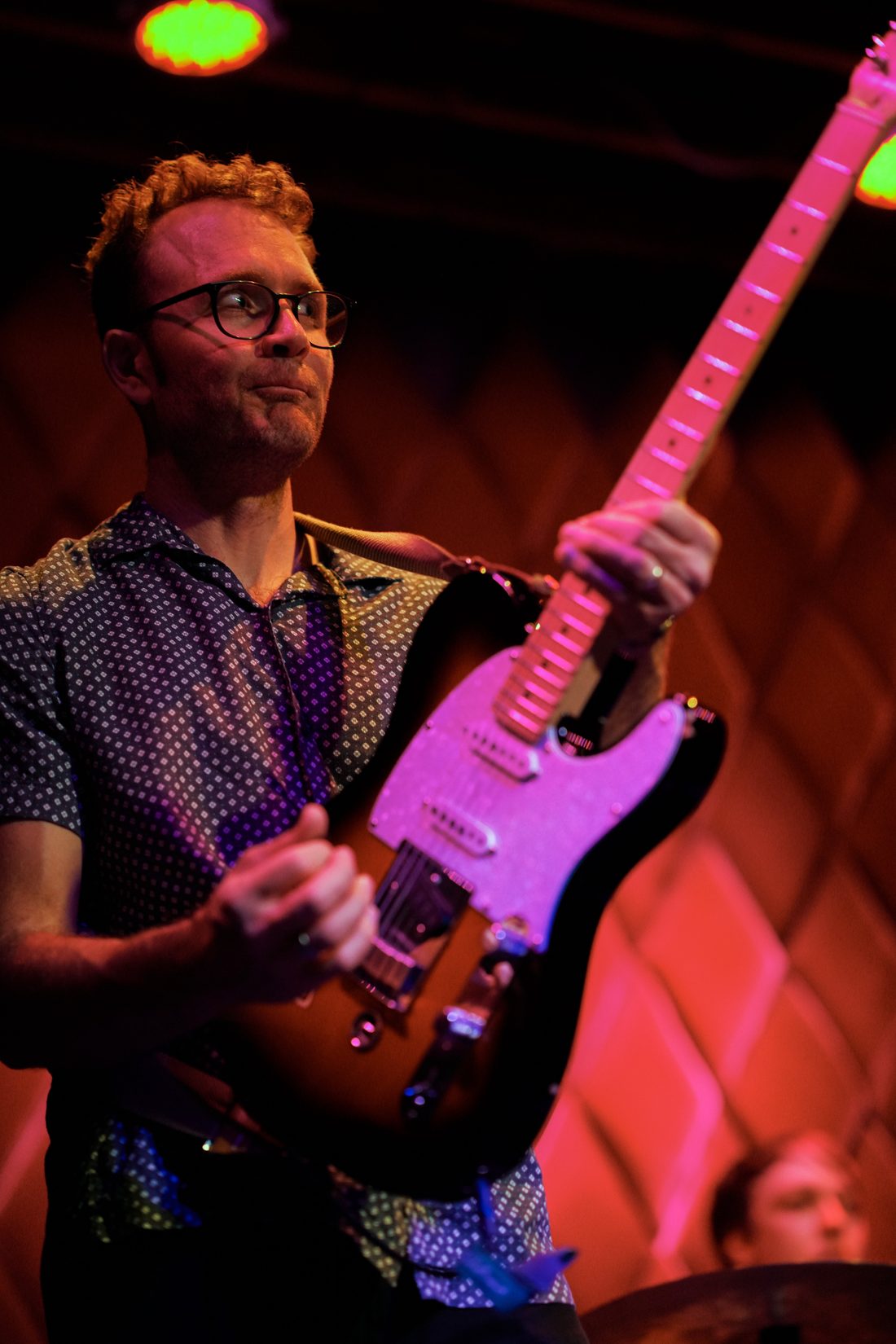 Guitarist under red and green stage light